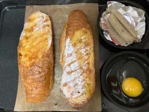 ヘルシオの天板にクッキングシートを敷いて、市販のフレンチトーストと目玉焼き用の卵、ソーセージを乗せたところ。