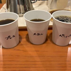 紙コップに入った、異なる抽出器具で入れたコーヒー3種。プレス、メタル、ペーパー