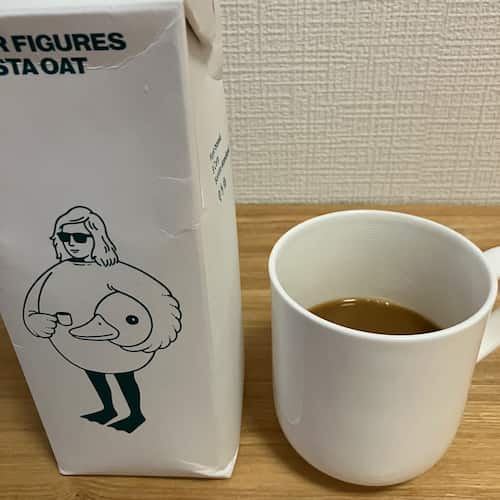 オーツミルクのパッケージと、カップに入ったオーツミルク入りコーヒー