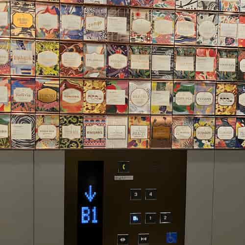 エレベーターの中、壁一面に貼られた歴代のティー&コーヒーカード