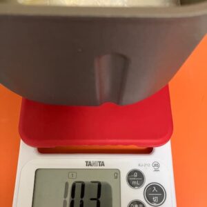 スケールの上に、パンケースを乗せて、水の量を計っているところ