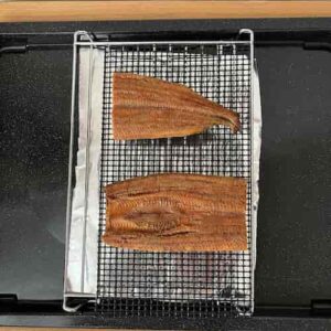 用意した網に、２等分に切って乗せたうなぎ