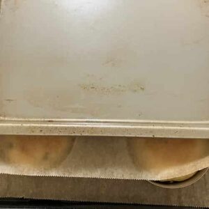 表面を平らにするために、イングリッシュマフィン型の上に、重しを乗せているところ